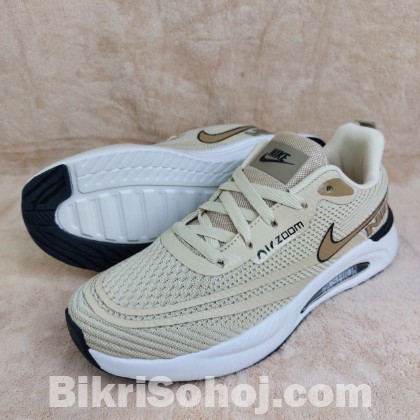 Nike Air Zoom running shoes in a light beige/tan colorway wi